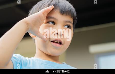 Heureux enfant asiatique souriant debout dehors et regardant vers l'avenir. Concept de portrait pour enfants. Banque D'Images