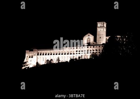 Vue panoramique sur assise dans la nuit dans la province de Pérouse dans la région Ombrie en Italie avec le basilique de Saint Francesco allumé Banque D'Images