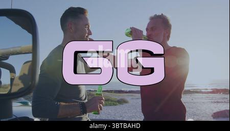 Clinking des bouteilles de bière en verre vert deux hommes les élevant au coucher du soleil sur la plage de sable, avec miroir de véhicule Banque D'Images