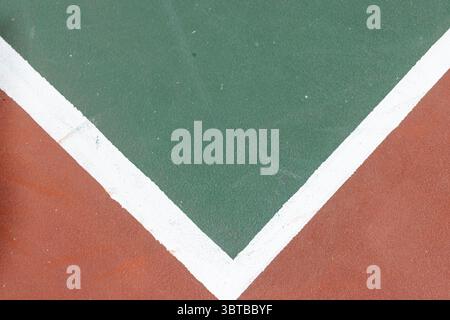 White V-shaped boundary line running across court, dividing reddish-brown and dark green sections Banque D'Images