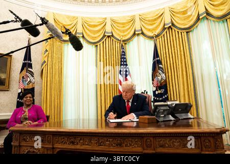 28 août 2020, Washington, District of Columbia, États-Unis : le président américain Donald J. Trump signe le document accordant à Alice Marie Johnson, avocate de la réforme de la justice pénale, une grâce complète au bureau ovale de la Maison Blanche à Washington, DC. M.S. Johnson regarde de gauche à droite (crédit image : © Anna Moneymaker/CNP via ZUMA Wire) Banque D'Images
