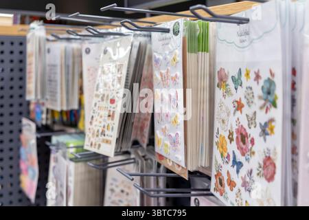 Poznan, Pologne - 30 juin 2025 : un présentoir de vente au détail présente des feuilles d'autocollants colorées, certains étiquetés Naklejki (polonais pour autocollants), parfait pour Back to SC Banque D'Images