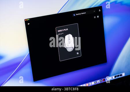 Poznan, Pologne - 30 juin 2025 : l'application de souris de jeu G502 X plus s'affiche à l'écran, montrant un design blanc élégant et une batterie de 54 % Banque D'Images