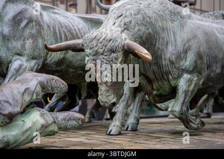 Cette sculpture saisissante de Pampelune présente de puissants taureaux dans des poses dynamiques, représentant le célèbre festival San Fermin qui a lieu chaque année en juillet. Banque D'Images