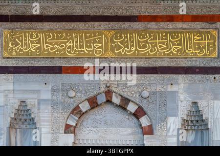 Vue détaillée de la fontaine d'Ahmed III à Istanbul, Turquie, montrant la calligraphie arabe dorée sur marbre avec des pierres complexes en dessous. Banque D'Images