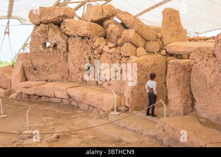 Mnajdra Malte, vue d'une touriste se tenant sur le seuil de l'entrée sud du temple à l'intérieur du site néolithique préhistorique de Mnajdra. Banque D'Images
