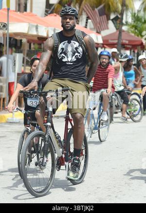 MIAMI BEACH, Floride - 16 AOÛT : LeBron James s'est présenté sur place à Miami Beach pour une publicité Nike. Le champion de la NBA a sauté sur un vélo et a roulé autour de la zone emblématique d'Ocean Drive avec quelques autres coureurs pendant que les caméras roulaient. Par la suite, le MVP de la NBA LeBron James a pris la tâche de gaspiller l'argent des contribuables, disant qu'il avait besoin d'aide pour se rendre à un concert de Justin Timberlake et Jay Z vendredi soir. La star de Miami Heat a ensuite posté une vidéo de lui disant qu'il suivait ''une escorte de police du mauvais côté de la rue'' pour se rendre au concert au Sun Life Stadium. La vidéo de huit secondes montre Banque D'Images