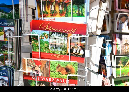 Forbach, Allemagne - 12 juillet 2025 : cartes postales de la Forêt-Noire allemande exposées sur un porte-cartes à vendre. Souvenirs touristiques du Schwarzwald reg Banque D'Images