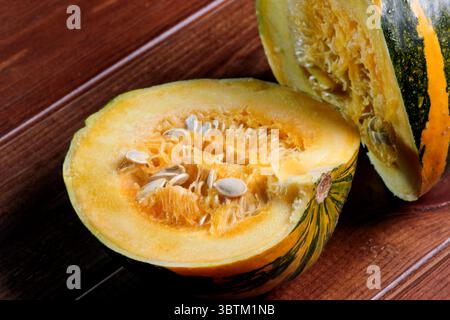 Une petite citrouille mûre et douce se trouve sur une table en bois brun gros plan Banque D'Images