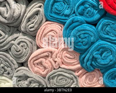 Serviettes roulées dans des rangées multicolores, présentoir d'étagère avec harmonie de texture douce Banque D'Images