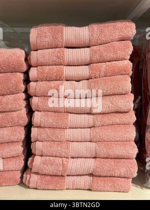 Serviettes roses pliées avec bandes décoratives, présentoir organisé sur tablette Banque D'Images