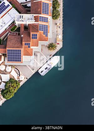 Vue aérienne d'un port baigné de soleil où les toits en terre cuite rencontrent les eaux turquoises, un yacht doucement amarré à côté, créant un contraste saisissant, Australie occidentale, Australie occidentale, Australie. Banque D'Images