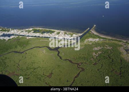 Vue aérienne de rivières sombres tortueuses serpentant à travers des zones humides verdoyantes, rencontrant la mer bleue tranquille près d'une ville côtière, Merida, Yucatan, Mexique. Banque D'Images