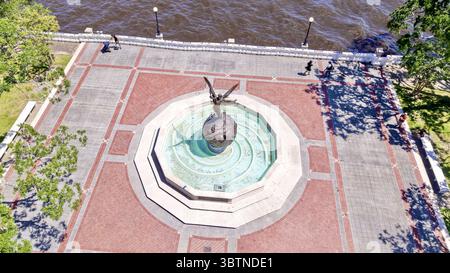 Vue aérienne d'une sculpture d'ange ailé debout au sommet d'une fontaine de globe sur une place de brique près de l'eau, Jacksonville, Floride, États-Unis. Banque D'Images
