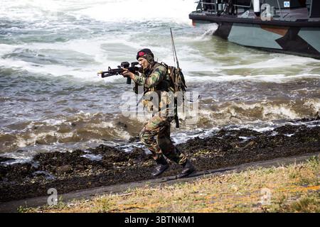 Soldat des Forces spéciales (Korps Mariniers) courant et visant son arme après avoir débarqué d'une embarcation de débarquement lors d'une manifestation d'assaut amphibie Banque D'Images