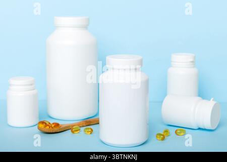 Les capsules Omega-3 se trouvent dans une bouteille blanche sur une table avec un fond de feuilles vertes. Comprimés d'huile de poisson. Additifs biologiquement actifs. omega 6, omega 9, vitam Banque D'Images