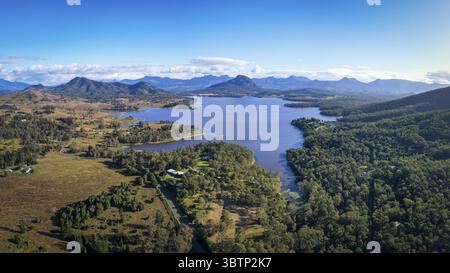 Vue aérienne des eaux tranquilles reflétant le ciel, embrassé par des forêts luxuriantes et des montagnes lointaines, un paysage serein se déploie., Boonah, Queensland, Australie. Banque D'Images