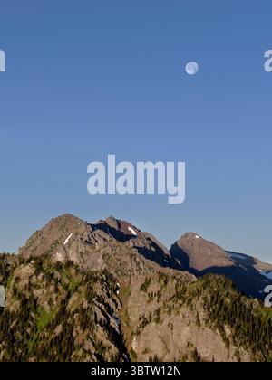 WA26679-00..... WASHINGTON -Lune au-dessus des montagnes olympiques depuis le mont Townsend dans la nature sauvage de Buckhorn. Banque D'Images