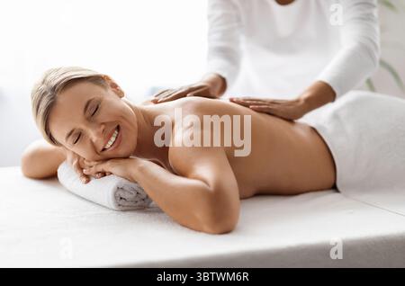 Portrait d'une belle femme mature ayant une séance de massage au salon Spa Banque D'Images