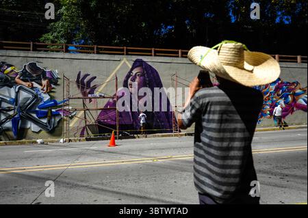 27 novembre 2019, San Salvador, San Salvador, El Salvador : un jeune homme prend une photo avec son téléphone portable d'un graffiti peint sur les murs d'un passage supérieur à San Salvador pendant la zone 503 : festival international du graffiti. (Crédit image : © Camilo Freedman/ZUMA Wire) Banque D'Images