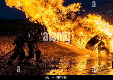 28 septembre 2020 - base aérienne de Dover, Delaware, États-Unis - les pompiers du 436th civil Engineer Squadron et de la Magnolia Volunteer Fire Company Station 55, du Delaware, pulvérisent un avion d'entraînement au feu lors d'un exercice de feu réel dans la nuit du 28 septembre 2020, sur la base aérienne de Dover, Delaware. La Force totale et les compagnies de pompiers civiles de la communauté environnante collaborent souvent avec la base aérienne de Douvres pour remplir les exigences annuelles de formation. Christopher Quail (crédit image : © U.S. Air Force/ZUMA Wire/ZUMAPRESS.com) Banque D'Images
