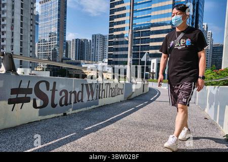 18 octobre 2020, Hong Kong, Chine : un homme portant un masque passe devant un graffiti ''#StandWithThailand'' à Hong Kong. Les activistes de Hong Kong ont exprimé leur solidarité avec le mouvement pro-démocratie thaïlandais sur les réseaux sociaux avec les hashtags ''#StandWithThailand'' et ''#MilkTeaAlliance'', une référence à une coalition d'activistes pro-démocratie asiatiques. (Crédit image : © Isaac Wong/SOPA images via ZUMA Wire) Banque D'Images