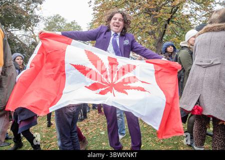 17 octobre 2018, Toronto, Canada : un homme dansant tenant un drapeau canadien avec une feuille de marijuana au milieu au lieu d'une feuille d'érable pendant la journée de célébration de la légalisation du cannabis au parc Trinity Bellwoods. (Crédit image : © Shawn Goldberg/SOPA images via ZUMA Wire) Banque D'Images
