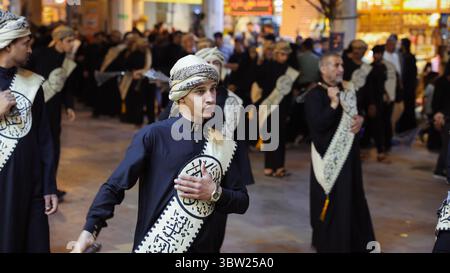 Les foules se rassemblent à an Najaf, en Irak, pour une célébration culturelle animée avec des gens en tenue traditionnelle dans une procession cérémonielle. Banque D'Images