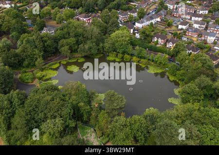 Smethwick, 15 juillet 2025. La police des West Midlands a placé un cordon autour d'un étang de pêche dans la région de Smethwick à Sandwell le mardi 15 juillet après que le corps d'une femme a été retiré de l'eau. Les agents se tenaient près de la bâche bleue où le défunt gisait dans le terrain de l'étang isolé près du centre récréatif de Thimblemill. Une ambulance était garée à proximité jusqu'à ce que les entrepreneurs arrivent dans une ambulance privée noire pour récupérer la victime. Crédit : British News and Media/Alamy Live News Banque D'Images