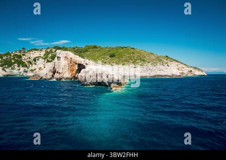Une vue panoramique d'une île rocheuse entourée d'un océan bleu profond sous un ciel clair. Banque D'Images