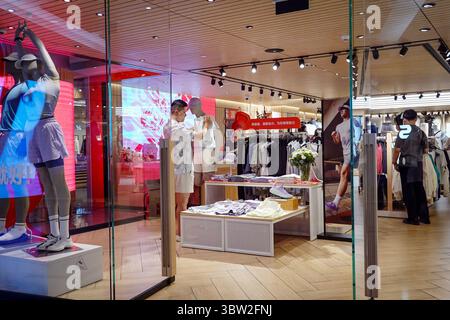 Pékin, Chine. 15 juillet 2025. Dans un magasin de vêtements de sport au Beijing International Trade Mall, Un homme essaie des vêtements tandis que des mannequins et des vêtements de sport soigneusement arrangés sont visibles. Les données de NBS montrent que les ventes au détail en Chine ont augmenté de 5 % en glissement annuel au premier semestre 2025, contre 4,6 % au premier trimestre. Crédit : SOPA images Limited/Alamy Live News Banque D'Images