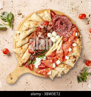 Délicieux panneau de charcuterie présentant de la viande salée, du fromage et des herbes aromatiques Banque D'Images