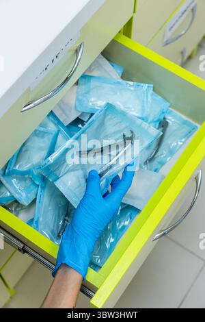 Outils dentaires organisés en attente d'utilisation : la précision d'un pharmacien dans la préparation d'instruments stérilisés, vitrine de l'hygiène et des soins en médecine Banque D'Images