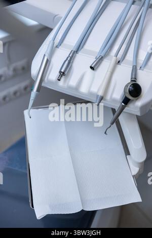 Vue rapprochée de l'équipement dentaire : outils et instruments modernes préparés pour les soins aux patients dans un environnement clinique dentaire lumineux et stérile Banque D'Images