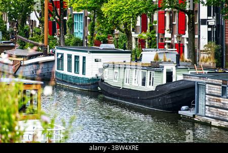 Les péniches bordant un canal à amsterdam, aux pays-bas, offrent une perspective unique sur la vie urbaine Banque D'Images