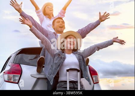 Heureux amis asiatiques bras et respira largement diffuser l'air frais avec bonheur dans l'humeur sur raod trip dans coffre de voiture. Les personnes en voyage de vacances longue vie Banque D'Images