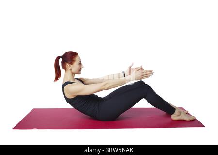 Exercice Pilates retour. Une femme élancée effectue un exercice pour renforcer et étirer son dos et sa colonne lombaire. Une forme physique intelligente pour le corps. Isol Banque D'Images