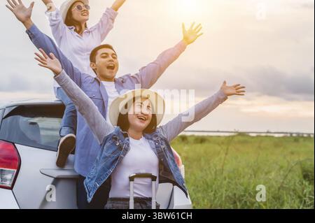 Heureux amis asiatiques bras et respira largement diffuser l'air frais avec bonheur dans l'humeur sur raod trip dans coffre de voiture. Les personnes en voyage de vacances longue vie Banque D'Images