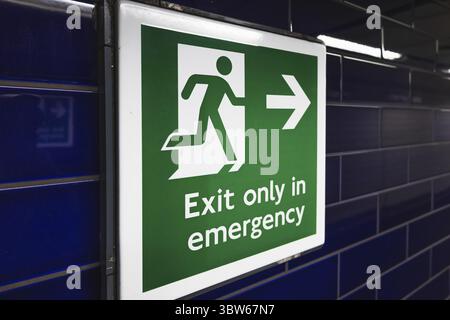 Panneau vert de sortie de secours avec icône homme en train de courir et flèche pour des consignes de sécurité Banque D'Images