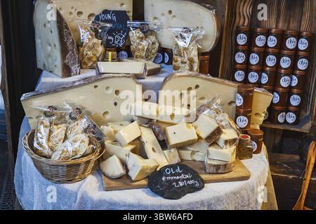 Variété de fromages artisanaux exposés sur des planches de bois à l'étal alimentaire animé de Borough Market à Londres. Londres, Royaume-Uni, 29 mars 2024 Banque D'Images