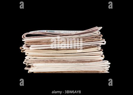 une pile de journaux isolés sur fond noir Banque D'Images