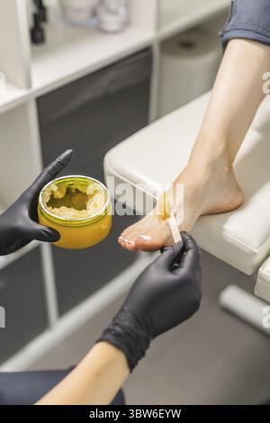 Frau, die Fusspeeling im Pedikuere SPA salon macht. Zuckerpeeling und entspannen Schoenheit Verfahren Banque D'Images