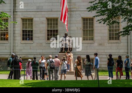 Cambridge, ma, USA - 15 juillet 2025 : vue de la statue de John Harvard en quad universitaire sur le campus de cette université privée de recherche Ivy League. Banque D'Images