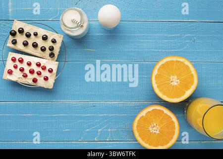 Petit déjeuner sain. Sandwiches sucrés avec fromage à la crème et baies fraîches et fruits sur fond bleu. Toasts pour le petit déjeuner. Vue de dessus. Copier l'espace Banque D'Images