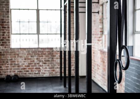 Illustration de conception plate montrant des anneaux de gymnastique suspendus à des poutres noires dans le gymnase loft avec fenêtre Banque D'Images