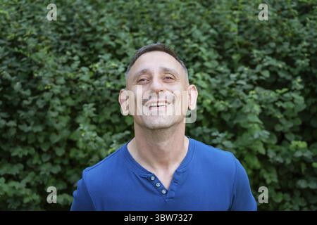Beau portrait d'un homme dans un T-shirt bleu sur un parc Banque D'Images