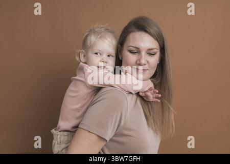 Enfant sourd fille avec implant cochléaire étudiant pour entendre les sons et s'amuser avec sa mère - récupération après chirurgie d'implant cochléaire et réadaptation co Banque D'Images