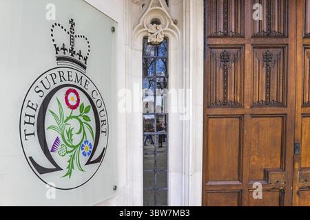 L'entrée de la Cour suprême à Londres affiche l'emblème officiel et les portes traditionnelles en bois. Londres, Royaume-Uni, 16 mars 2024 Banque D'Images