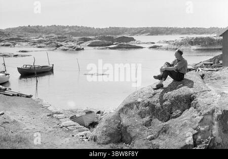 Aktuell 26 - 6 - 1970 : L'été du sud de la Norvège attend. Nous avons fait une escapade à la plage fugace dans l'un des paradis de vacances du sud de la Norvège, Brekkestø, et pouvons le signaler : les campings, les maisons d'hôtes et les résidents locaux attendent l'invasion de vacances de l'été. Attente avec le soleil, bakingSvaberg et la morue qui vont sur les leurres et les filets. Le pêcheur Arnulf Andersen arrange ses filets après la prise de la nuit. Il n'y avait que six kilos de morue sur deux filets. Il est un résident permanent au milieu du paradis estival et ne pouvait imaginer quitter son île pour vivre au centre. Photo : Aage Storløkken / A Banque D'Images