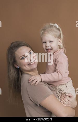 Enfant sourd fille avec implant cochléaire étudiant pour entendre les sons et s'amuser avec sa mère - récupération après chirurgie d'implant cochléaire et réadaptation co Banque D'Images